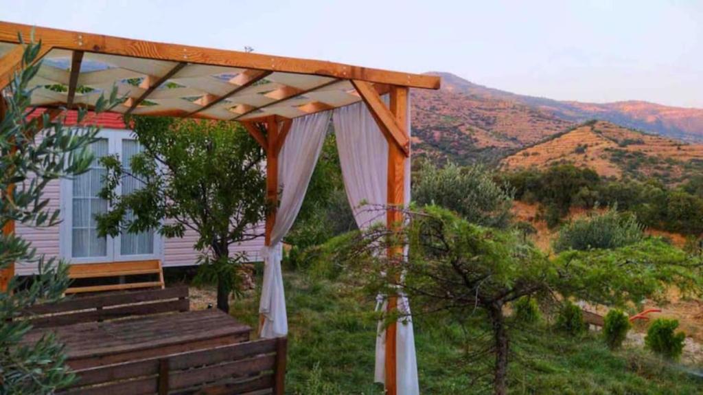 a house with a pergola and a table and bench at Hayal Tadında in Izmir