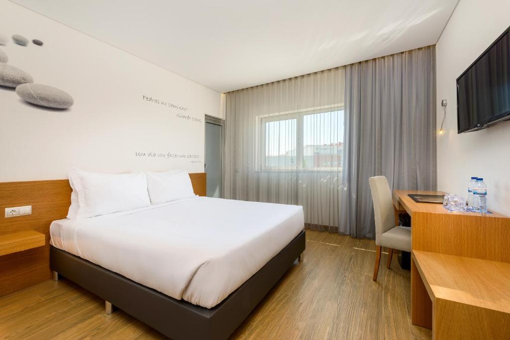 a hotel room with a bed and a desk at TRYP by Wyndham Leiria in Leiria