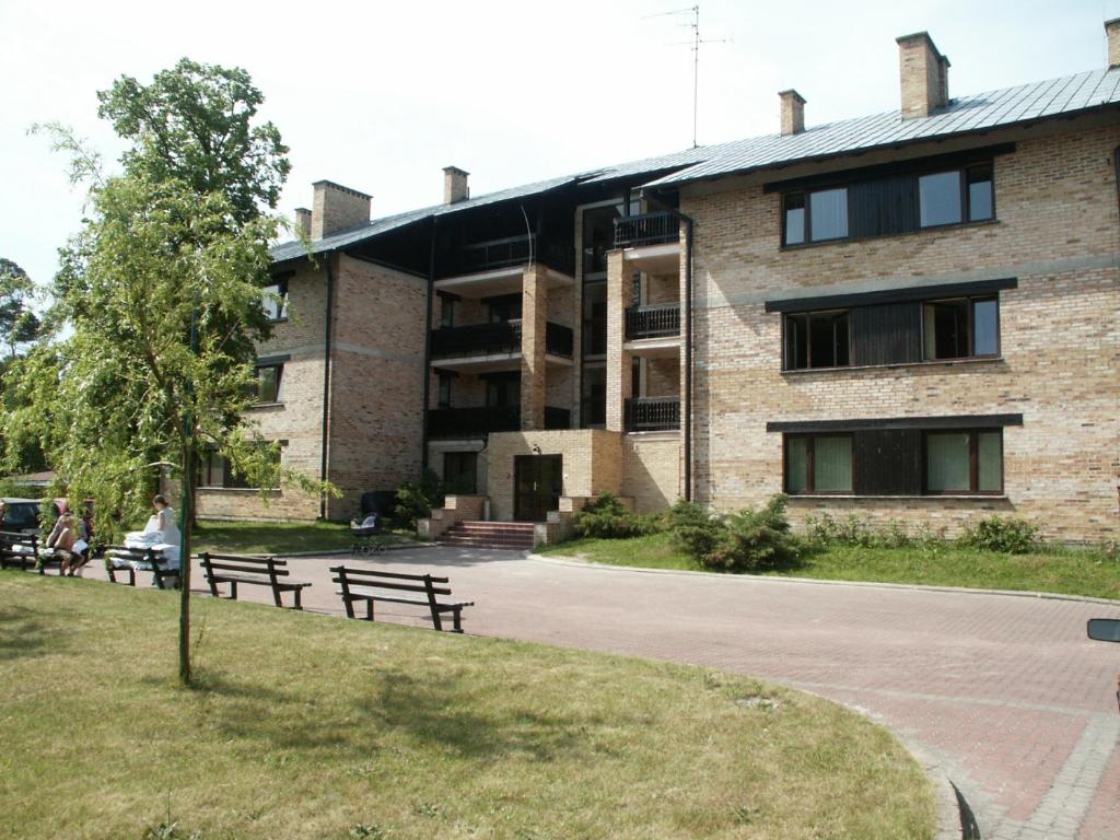 budynek z ławkami przed budynkiem w obiekcie Leśny Dwór w mieście Mielno