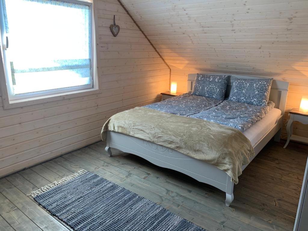 Lawendowe domki في كارفيا: غرفة نوم مع سرير ووسائد زرقاء ونافذة