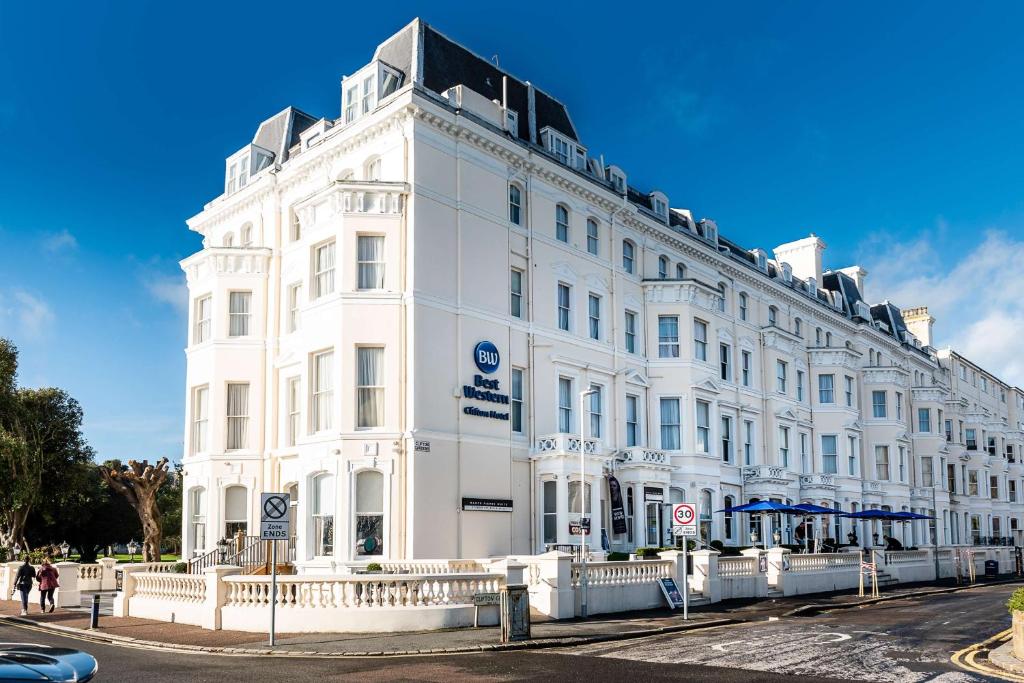 un grand bâtiment blanc au coin d'une rue dans l'établissement Best Western Clifton Hotel, à Folkestone