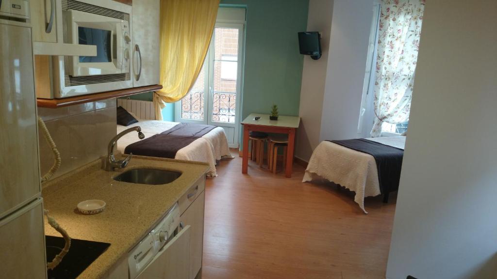 kuchnia ze zlewem i 2 łóżka w pokoju w obiekcie Hosteria Villa de Castro w mieście Castro-Urdiales