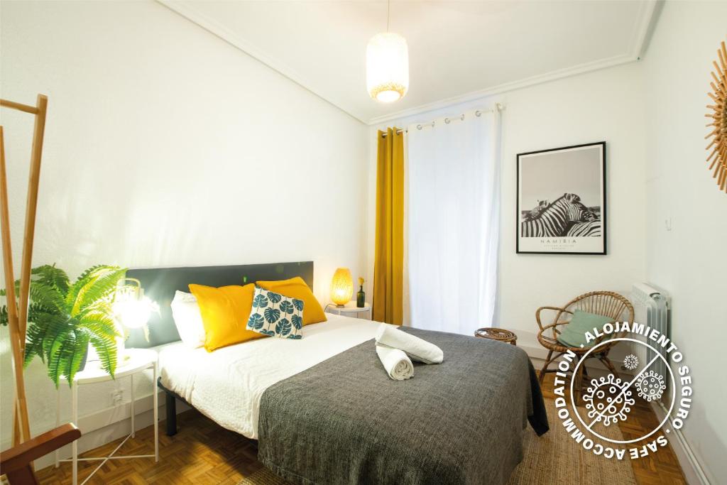 1 dormitorio con 1 cama y 1 silla en Espacioso, Moderno y a pie de Playa Zurriola, en San Sebastián