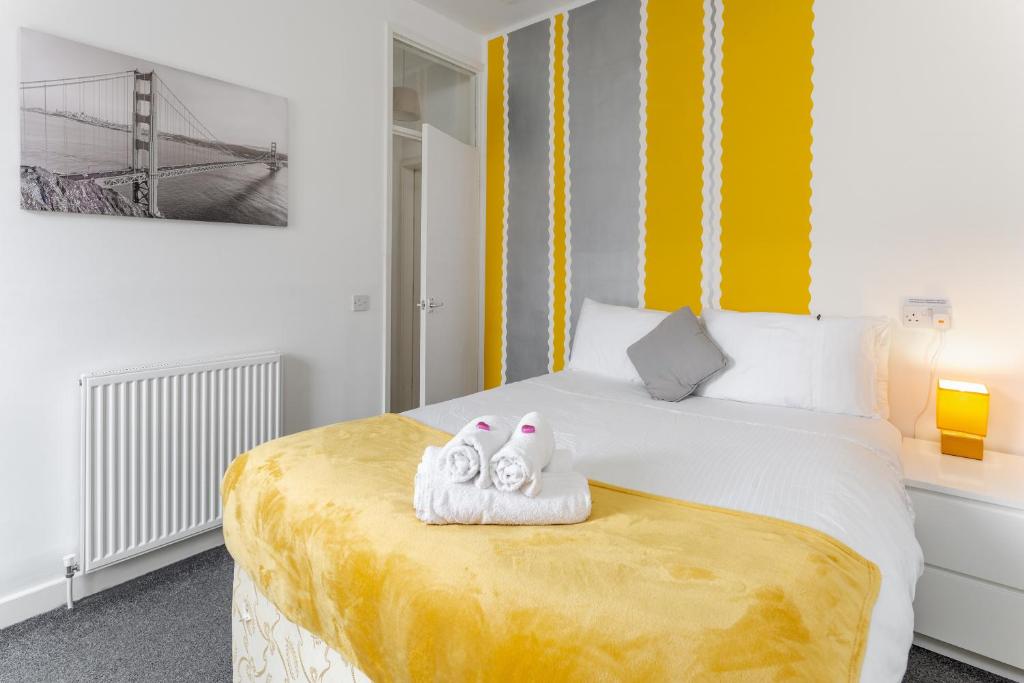 1 dormitorio con 1 cama con 2 toallas en Comfortable Liverpool Townhouse - FREE parking, en Liverpool