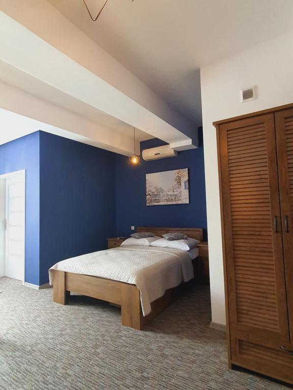 a bedroom with a bed with a blue wall at Apartament Stojałowskiego 35 in Bielsko-Biała