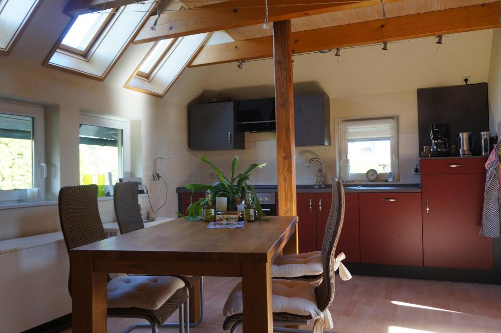 cocina con mesa de madera y algunas ventanas en Ferienwohnung Zündholz en Benneckenstein