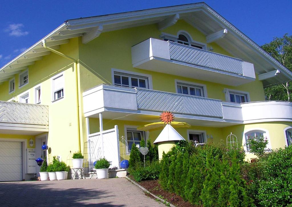 een geel huis met een balkon erboven bij Haus Sonnenhang in Lam