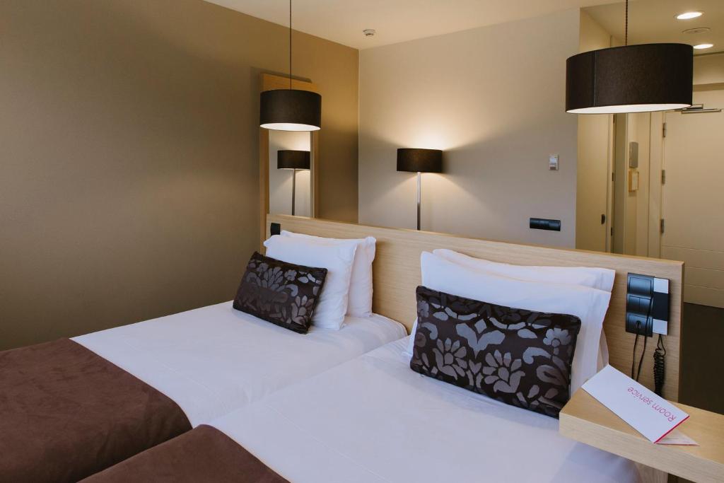 a bedroom with two beds and two pillows at PCM Forum Alcalá in Alcalá de Henares