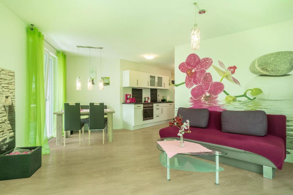 a living room with a purple couch and a table at Ferienwohnung Orchidee in Sipplingen