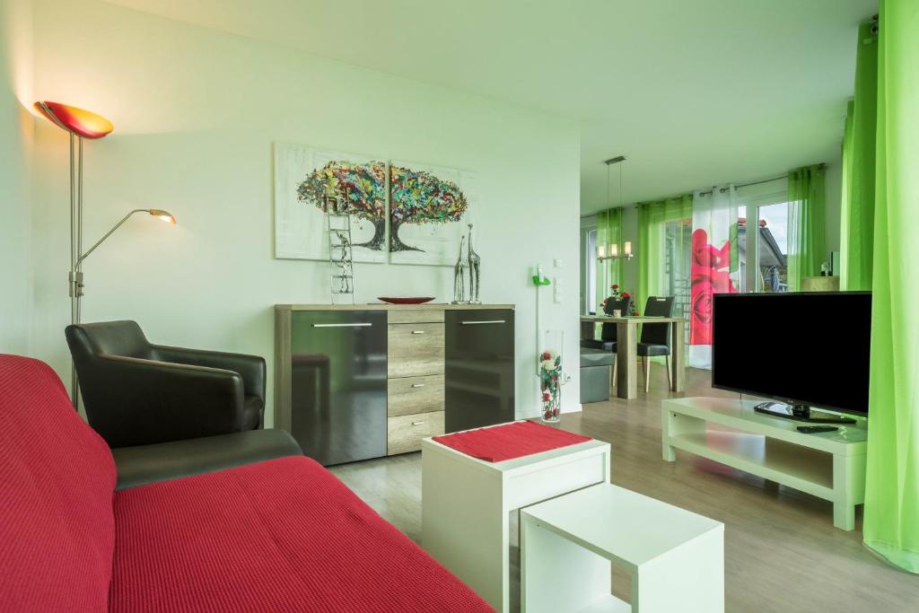 a living room with a red couch and a tv at Ferienwohnung Rose in Sipplingen