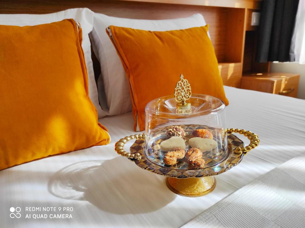 taca ciasteczek w szklanym talerzu na łóżku w obiekcie Lebon Hotel-Special Class w Stambule
