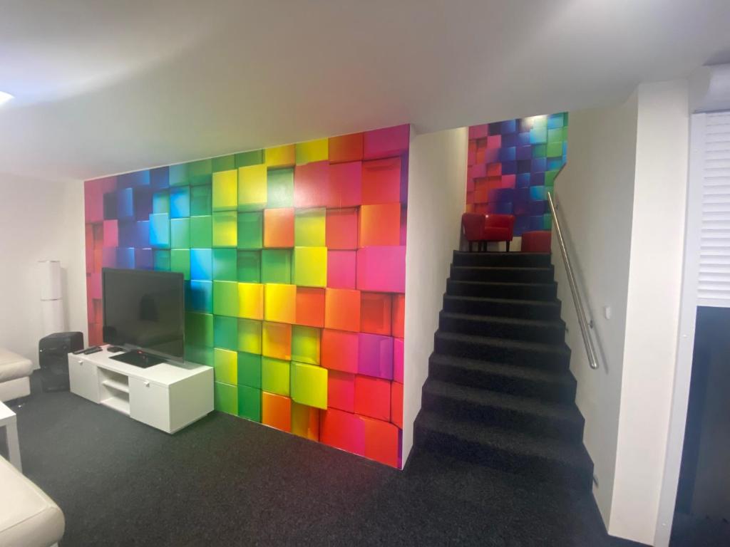 a colorful wall in a room with a staircase at WELLNESS APARTMÁN KAROLÍNA in Milovice