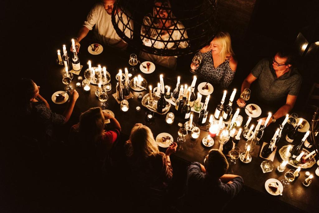 Un groupe de personnes assises autour d'une table avec des bougies dans l'établissement Scarpa Villas - Barolo Luxury Escape, à Verduno