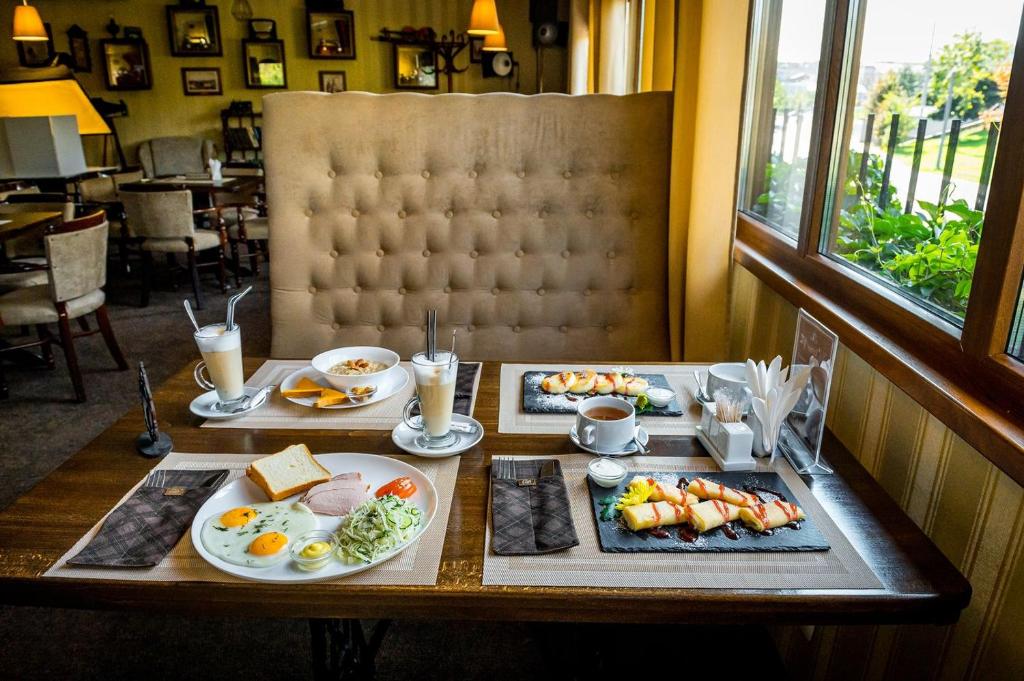 a table with plates of breakfast food on it at Guest House Shale in Vinnytsya