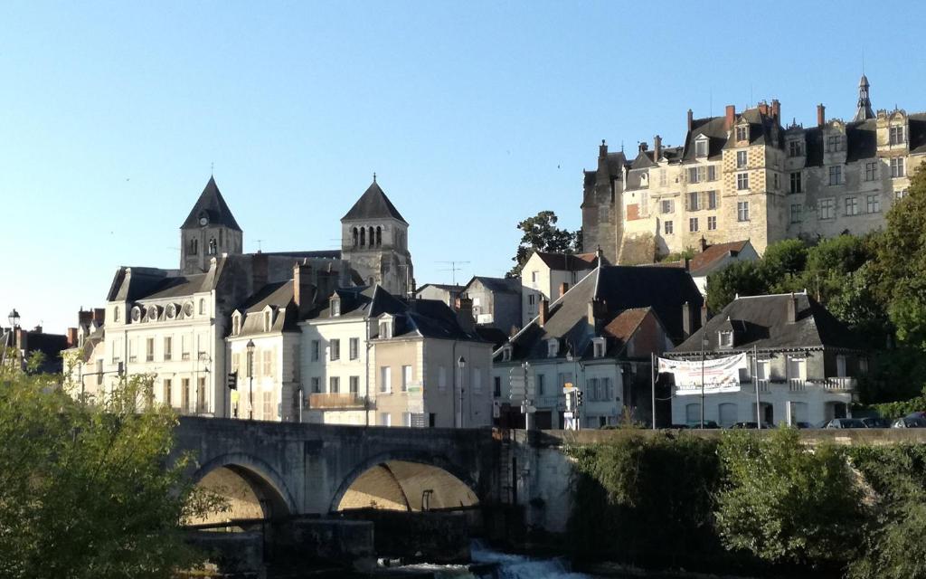 un gran edificio en una colina con un puente en Au pied du château, en Saint-Aignan