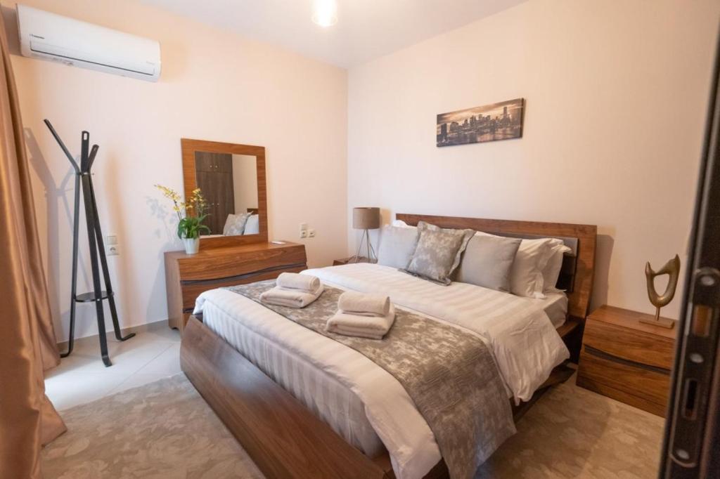a bedroom with a large bed with two towels on it at Meteora 360 Apartment by Meteora Residencies in Kalabaka