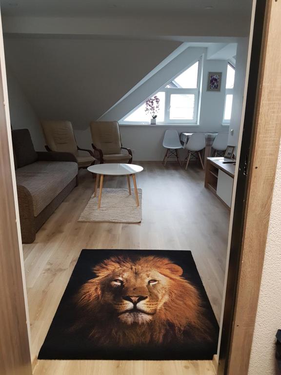 uma sala de estar com um tapete de leão no chão em Liūto apartamentai em Juodkrantė