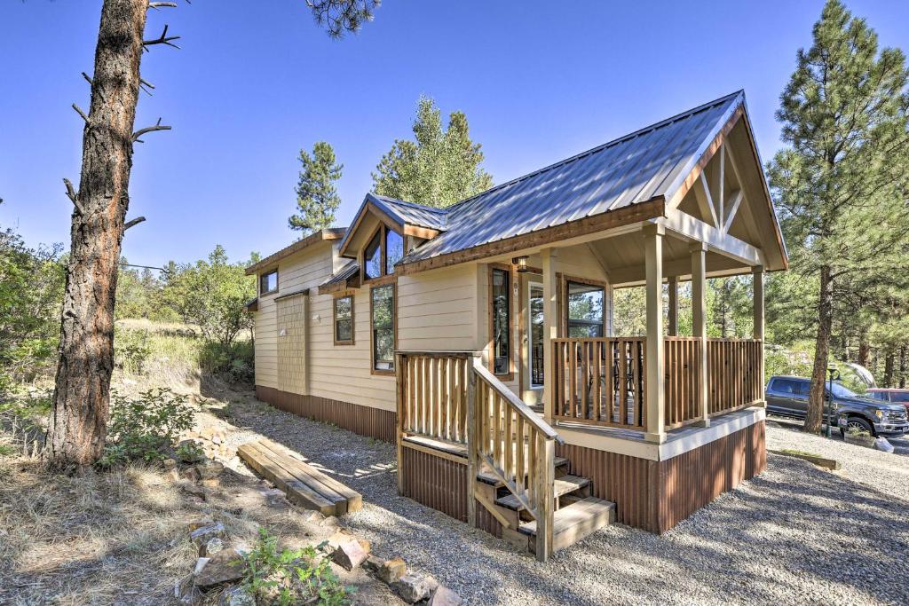 una cabina nel bosco con tetto di metallo di Roomy Pagosa Springs Tiny Cabin 1 Mi to Downtown a Pagosa Springs