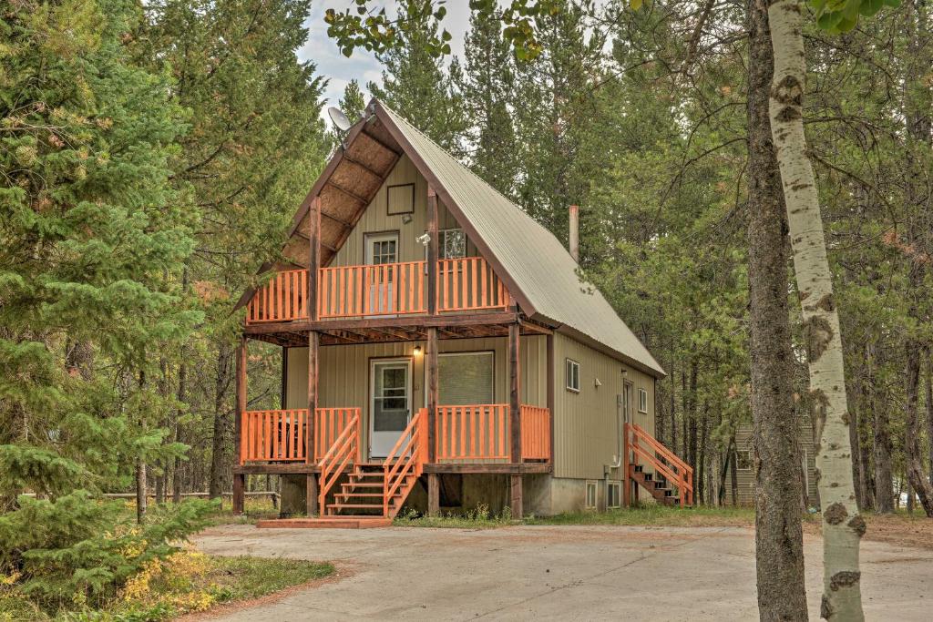 a large house with a deck in the woods at Family Cabin with Fire Pit - 25 Miles to Yellowstone in Island Park