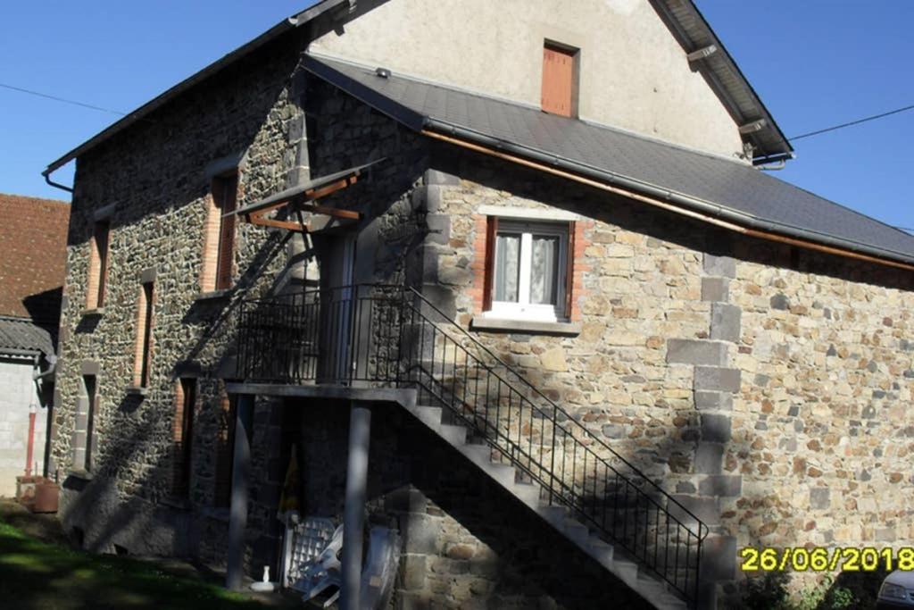 a brick building with a staircase on the side of it at GITE à LA FERME PRES VULCANIA-GR89 in La Goutelle