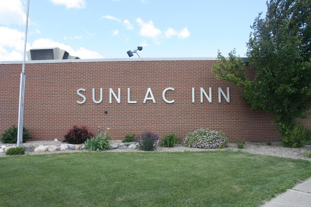 un edificio de ladrillo rojo con un cartel que lee la posada del amanecer en Sunlac Inn Lakota, en Lakota
