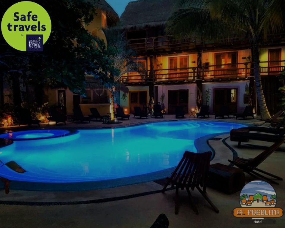 a large swimming pool in a resort at night at Hotel El Pueblito in Holbox Island
