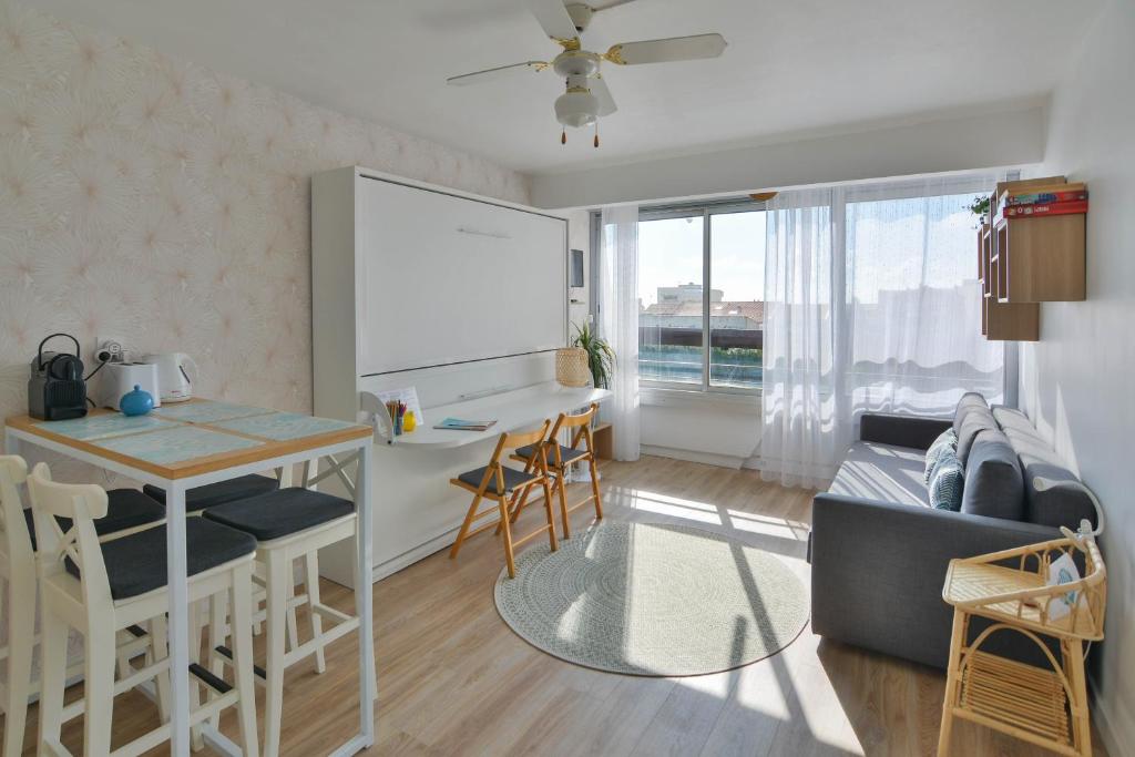 een keuken en een woonkamer met een tafel en een bank bij Studio Carnon, plage, port et commerces à 2 pas in Carnon-Plage