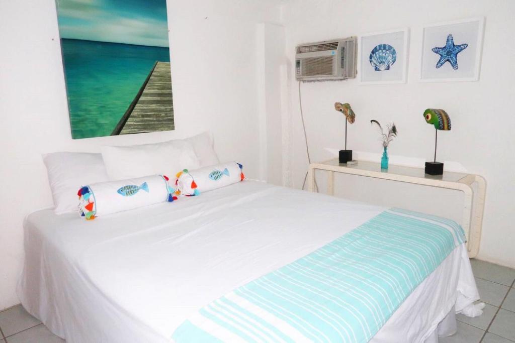 a bedroom with a white bed with two pillows at Apartment Brazil Beach Front Paradise in Savaneta