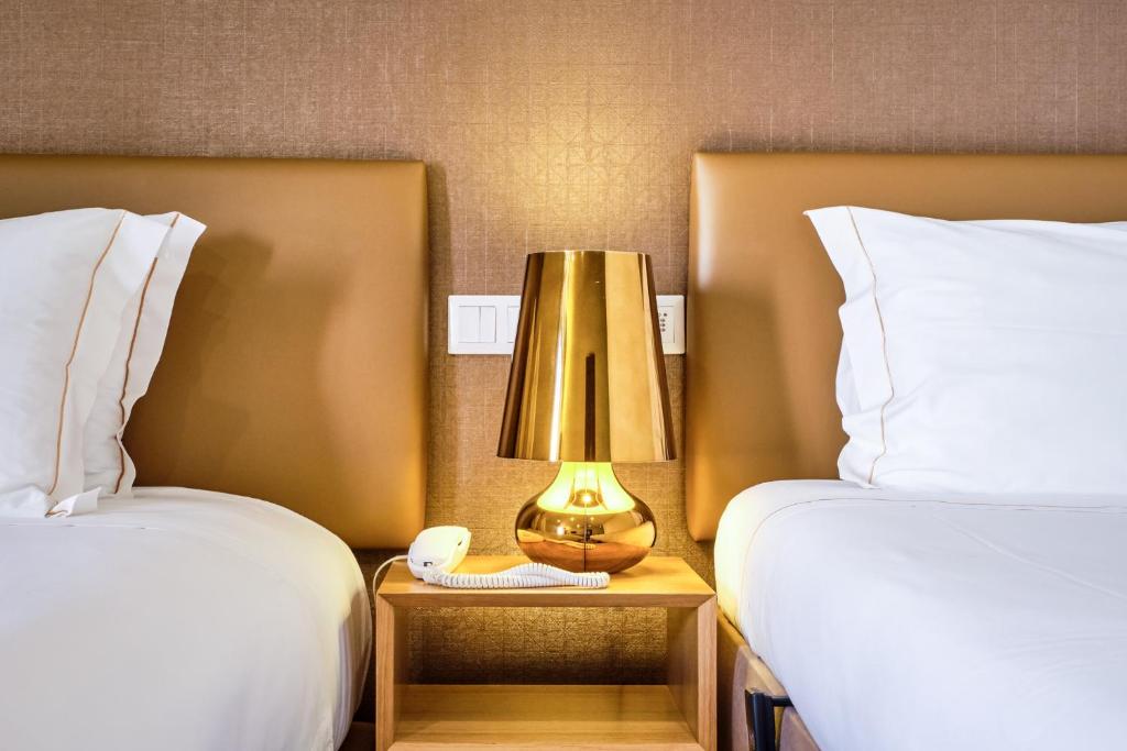 a lamp on a night stand next to two beds at Sintra Boutique Hotel in Sintra