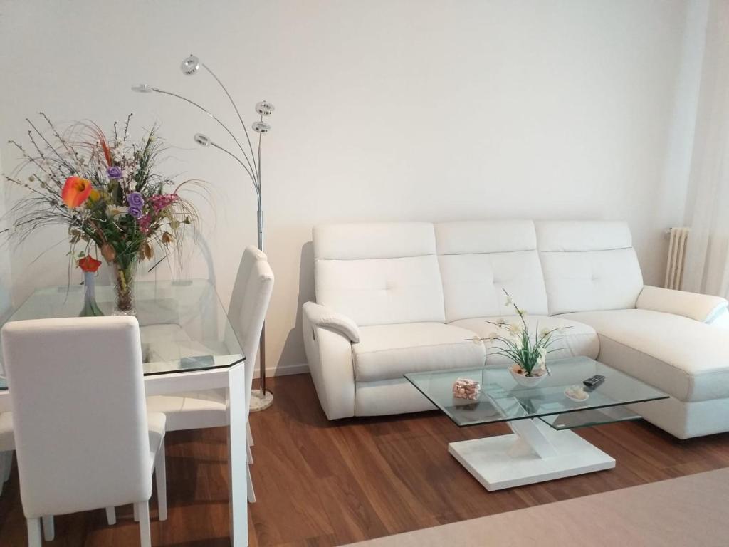 a living room with a white couch and a table at Sesto Calende Centro in Sesto Calende