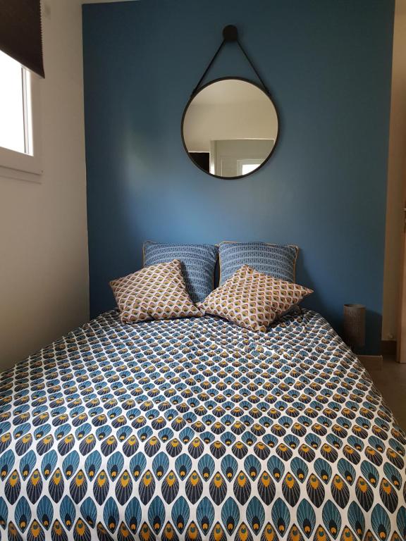 1 dormitorio con 1 cama con espejo en la pared en Chambre d'hôtes du Muguet avec SdB privative en Le Mans