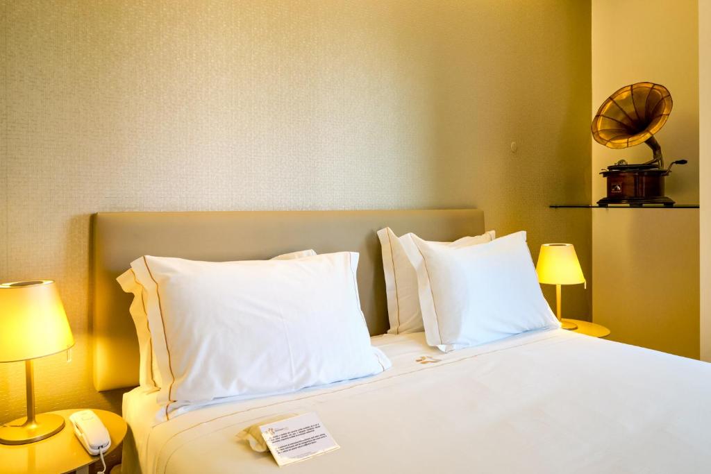 a hotel room with a bed with white pillows at Sintra Boutique Hotel in Sintra