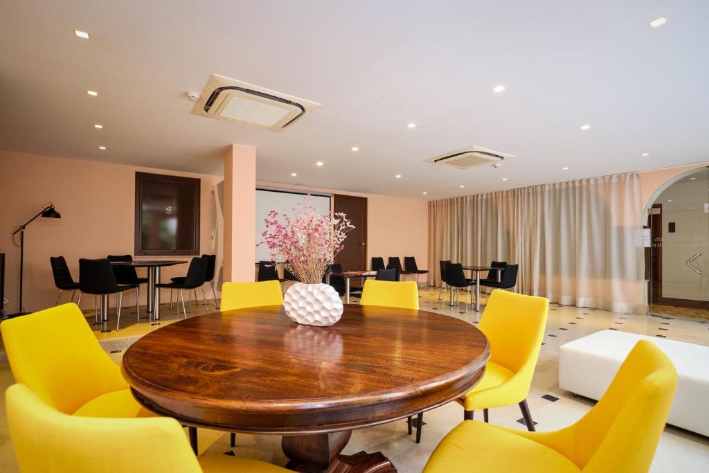 a dining room with a table and yellow chairs at Sintra Boutique Hotel in Sintra