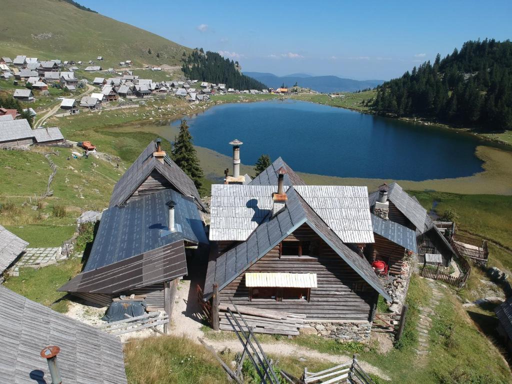 Koliba - Prokoško jezero في فوينيتسا: اطلالة جوية على منزل على تل بجوار بحيرة
