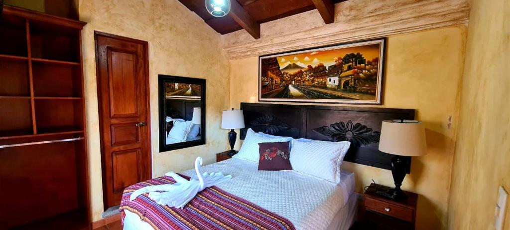 - une chambre avec un lit et une peinture murale dans l'établissement Hotel Casa Real Antigua, à Antigua Guatemala