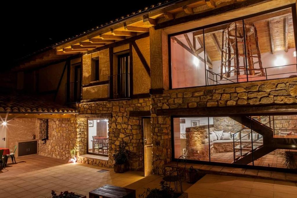 un grande edificio in pietra con grandi finestre di casa rural Sierra del Solorio (posada de Iruecha) a Iruecha