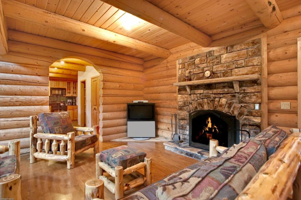 - un salon en rondins avec une cheminée dans l'établissement Hideaway Cabin, à Breckenridge