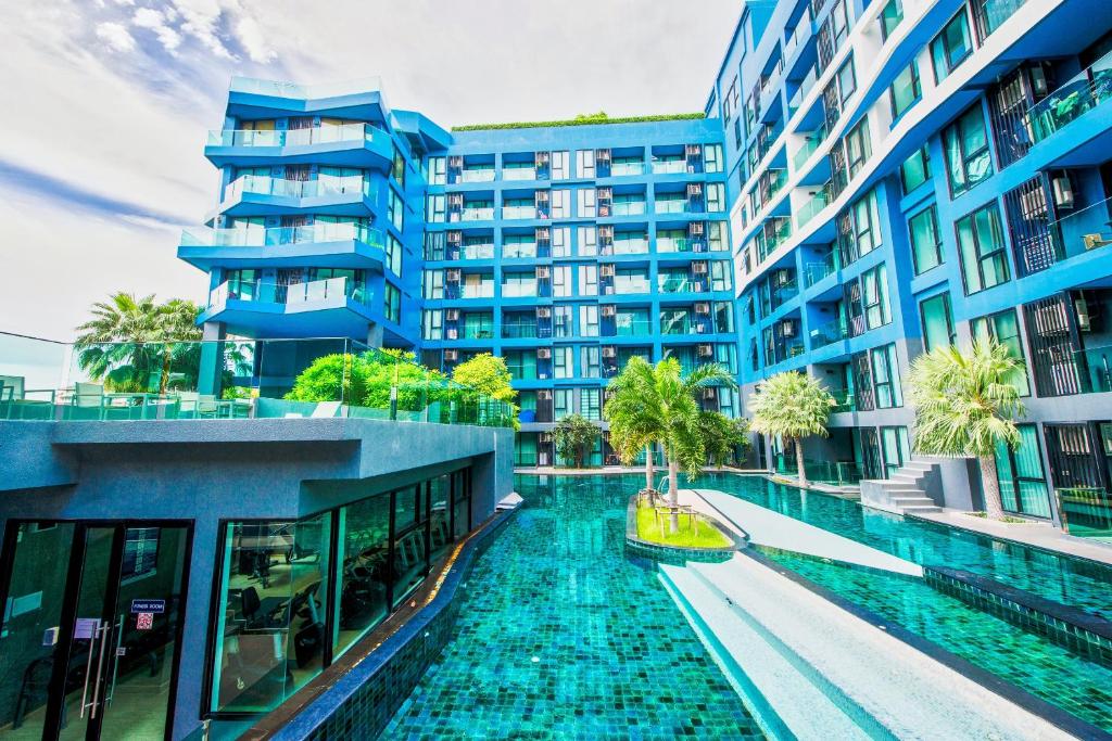 un edificio de apartamentos con piscina frente a él en Acqua Jomtien en Jomtien Beach