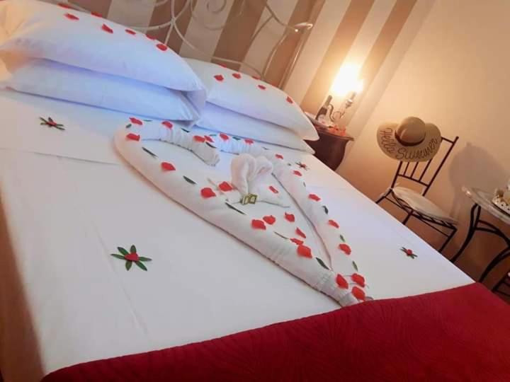 斯卡法第的住宿－POMPEI HOUSE，一张白色的床,上面有红色的鲜花