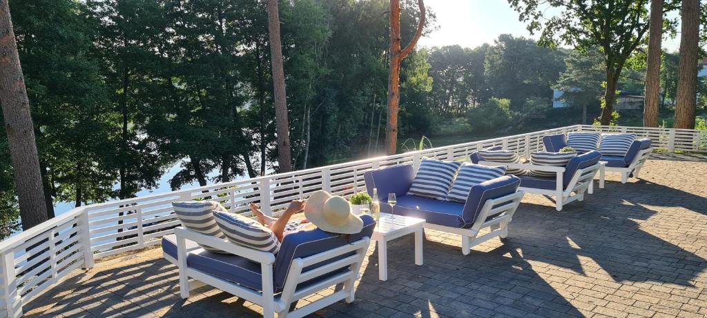 szereg krzeseł i stołów na patio w obiekcie Przystań na Zagórzu - Apartamenty nad jeziorem w mieście Drezdenko