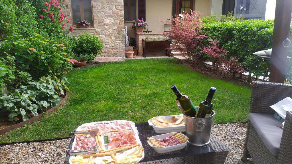 een tafel met een dienblad met eten en flessen wijn bij Il Giardino della Fortezza in Montepulciano