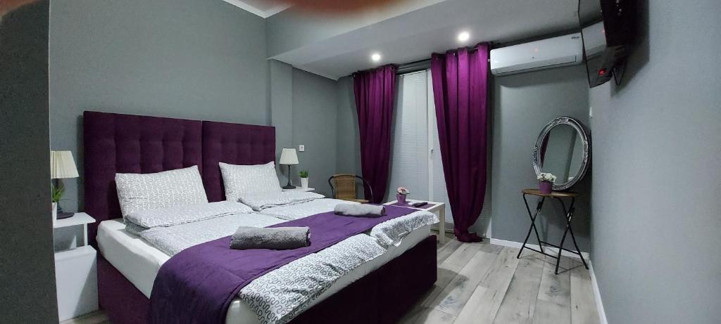um quarto com uma cama roxa e um espelho em Villa Bratislava em Demir Kapija