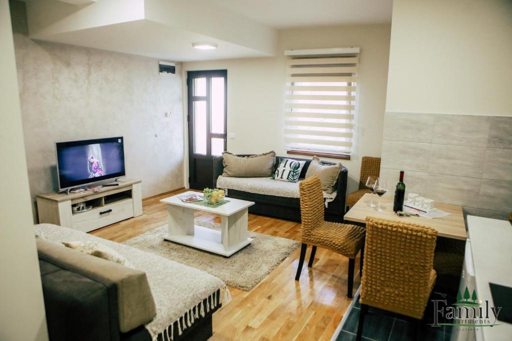 een woonkamer met een bank en een tv bij FAMILY APARTMENTS 1 in Zlatibor