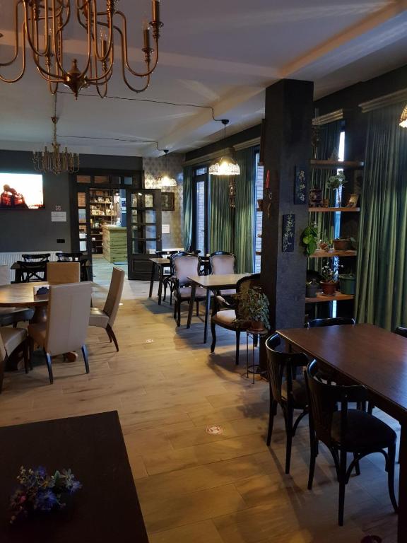 una sala da pranzo con tavoli, sedie e lampadario a braccio di Hilltop Kazbegi a Kazbegi