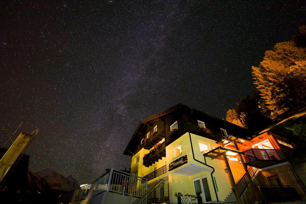 a house with the milky way in the night sky at Pension Bergkristall in Heiligenblut