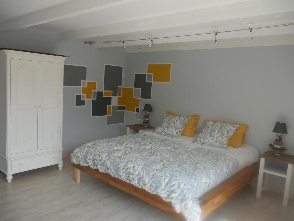 1 dormitorio con 1 cama con plazas coloridas en la pared en Opale des Caps en Leubringhen