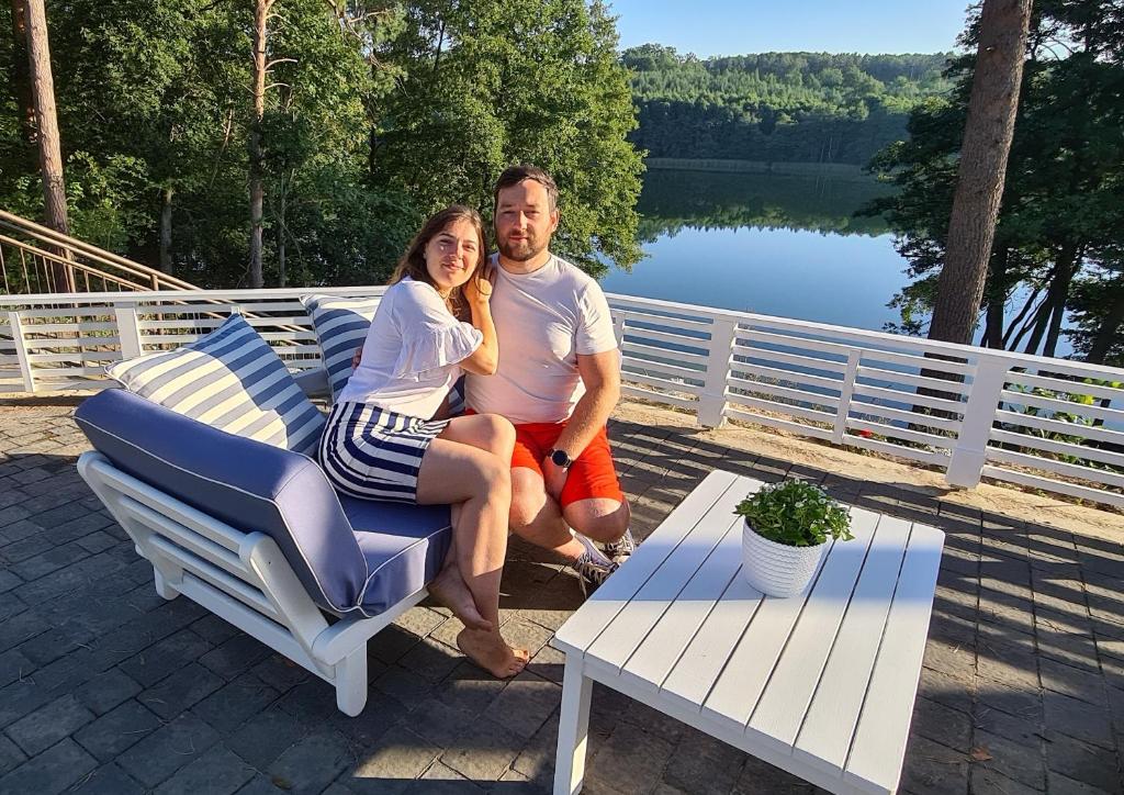 a man and a woman sitting on a chair at Przystań na Zagórzu - Apartamenty nad jeziorem in Drezdenko