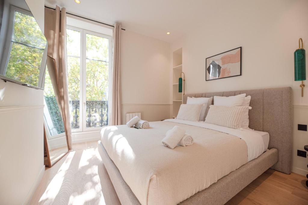 Un dormitorio blanco con una cama grande y una ventana en MBM - Luxury apartments PARIS CENTER, en París