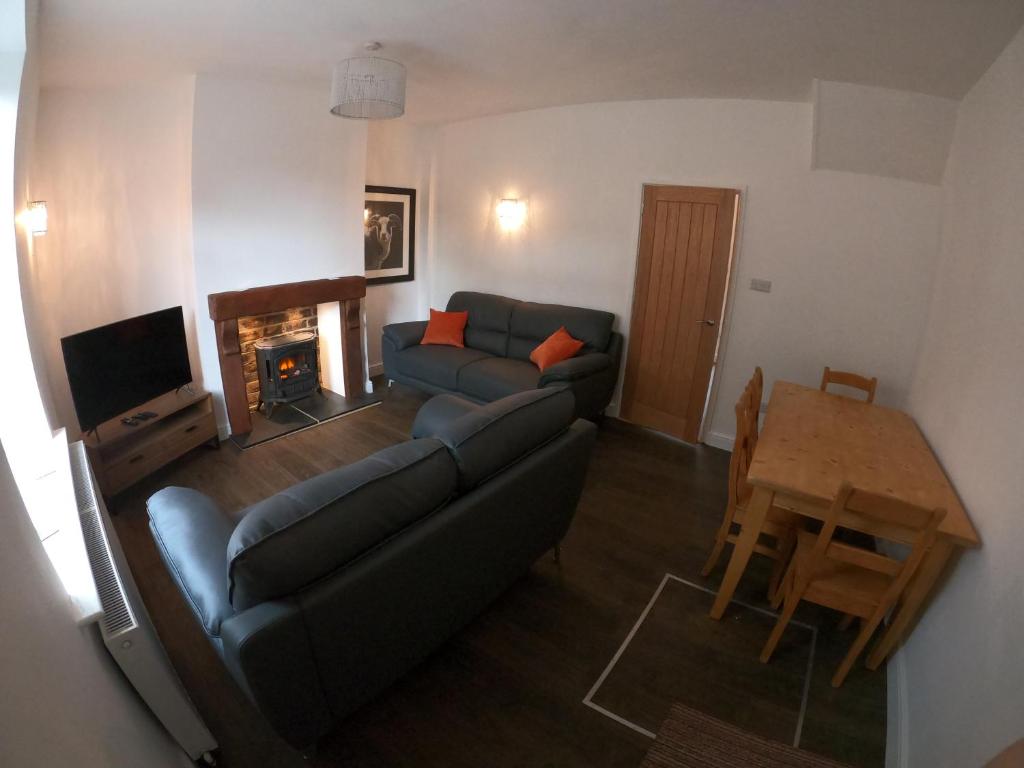a living room with a couch and a table at Albert Cottage in Skipton