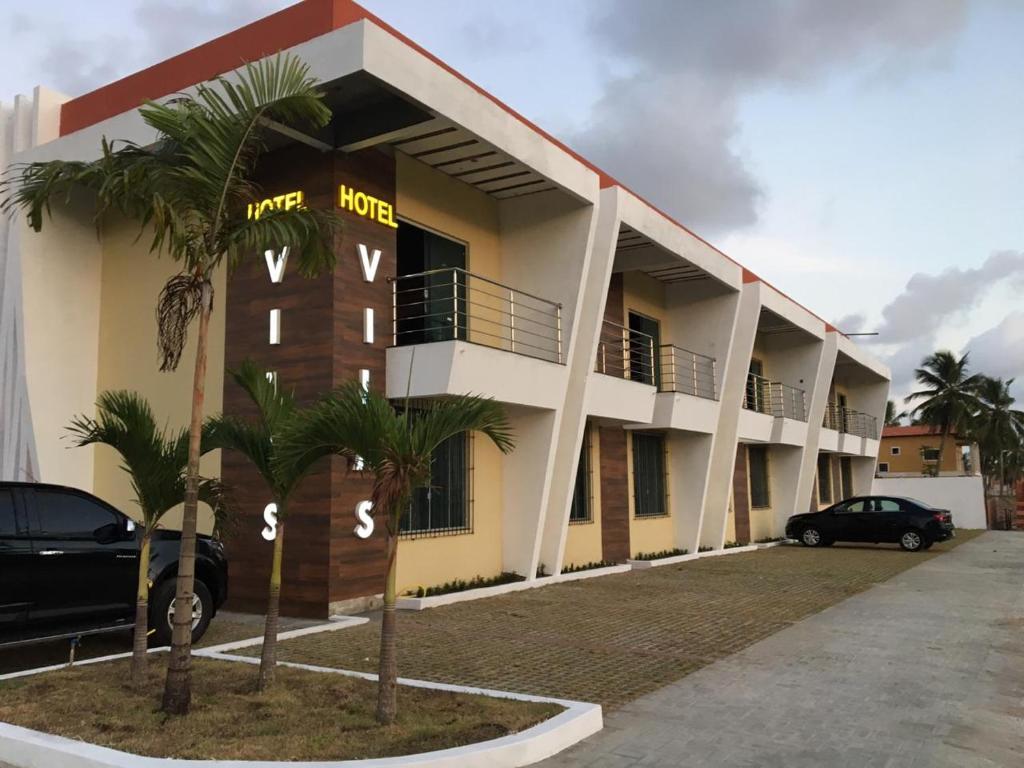 a hotel with cars parked in front of it at Hotel Vilas in Salinópolis